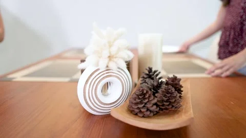 Hands Setting a Minimalist Dining Table with Pine Cones and Plates 스톡 동영상 337519938