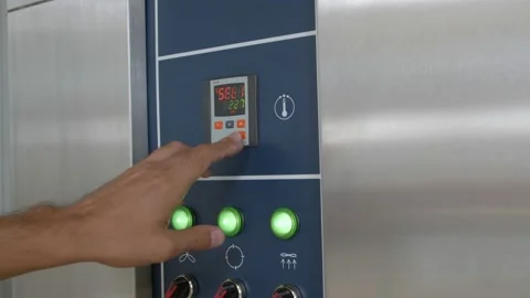 Hands setting time and temperature on the industrial bread oven control panel Stock Footage 153318781