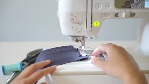 Hands on sewing machine making a face mask during corona virus pandemic Stock Footage 131538553