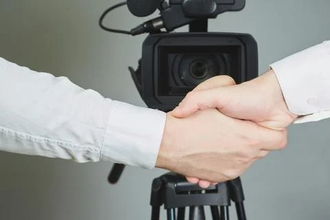 Hands shaking in front of a video camera, public contract, joint statement, p Stock Photos