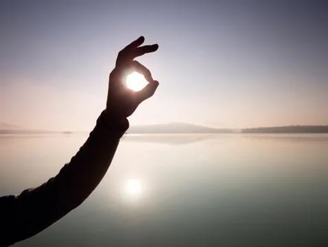 Hands in the shape of frame against  Sun. Shadow play over sea Stock Photos