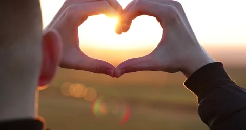 Hands in shape of love heart at sunset Stock Footage 229404350
