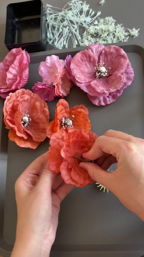 Hands shaping a bright handmade flower with decorative center on a craft table Stock Footage 345718534