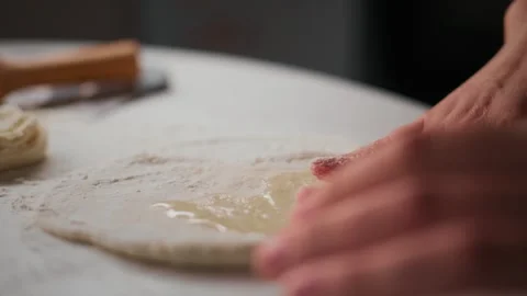 Hands shaping dough with care on flour-dusted counter Video stock 336097846