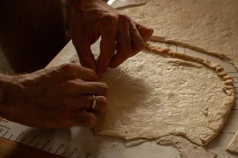 Hands shaping dough on a floured surface Stock Photos