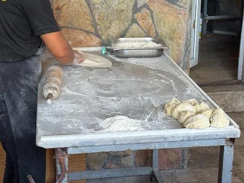 Hands shaping dough on a floured surface. Culinary process, preparation and a Stock Photos