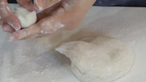 Hands Shaping Fresh White Dough on a Dusted Surface Stock Footage 345291835