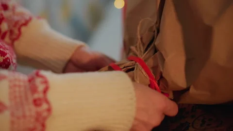 Hands shaping gift. Closeup of hands tying decorative ribbon on Christmas gift Stock Footage 338286037