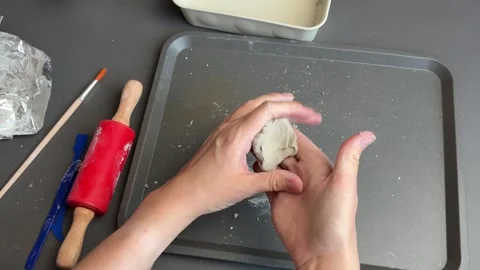 Hands shaping a rounded clay form for a handmade autumn pumpkin ornament Stock Footage 345719381