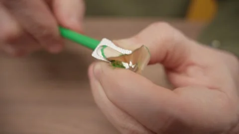Hands sharpening a green pencil with a small silver metal sharpener. Stock Footage 335209365