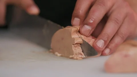 Hands сhef cutting foie gras with a knife raw lunch condiment preparation Stock Footage 103287852