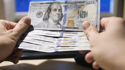 Hands show 100 Dollar bills on computer background Stock Footage 86291848