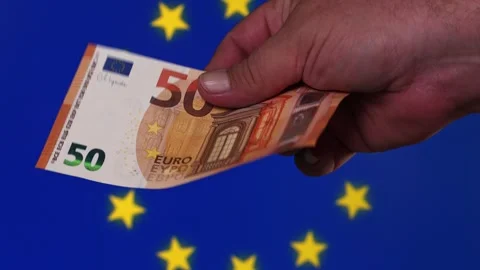 Hands show a 50 euro note with European Union flag background during a Stock Footage 331236393