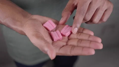 Hands show several pink chewing gum pieces, Stock Footage 337602809