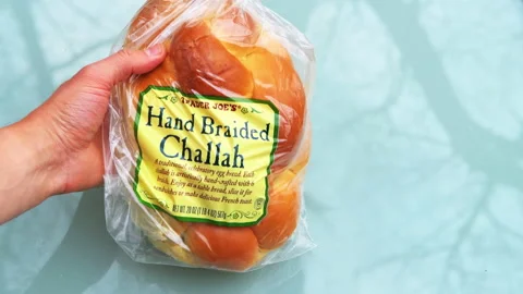 Hands showing Trader Joe's Jewish loaf of challah whole fresh bread Stock Footage 165245341