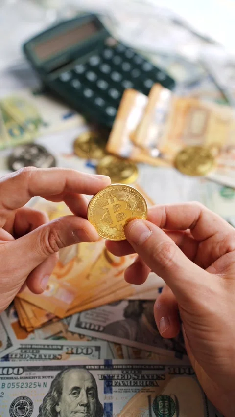 Hands shows BTC bitcoin against the dollars and euros Stock Footage 312015074