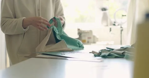 Hands of the skilled female worker putting the pin to the fabric Stock Footage 202516807
