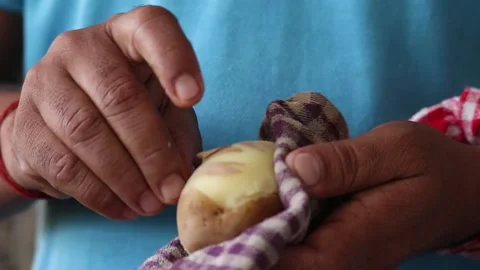Hands Of Skilled Labourer Cook Or Chef Peeling Boiled Hot Potato With Nails Stock Footage 146810949