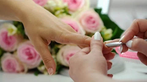 Hands of a skilled manicurist working on nails of a young woman Stock Footage 117836006