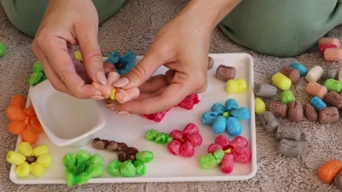 Hands skillfully create colorful flowers from eco-friendly corn material Stock Footage 316521632