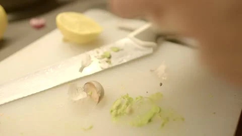 Hands skillfully peeling garlic in a cozy and warm kitchen atmosphere, showcasin Stock Footage 291932462