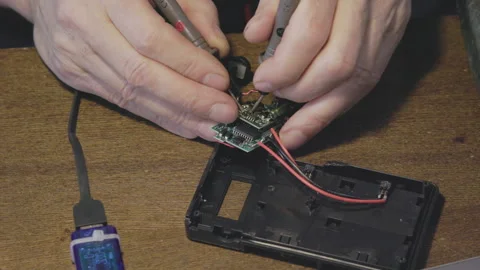 Hands Skillfully Repairing an Electronic Circuit Board Using a Multimeter for Video stock 306059516