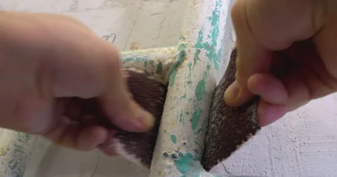 Hands skillfully sanding metal frame for restoration project Stock Footage 302347037