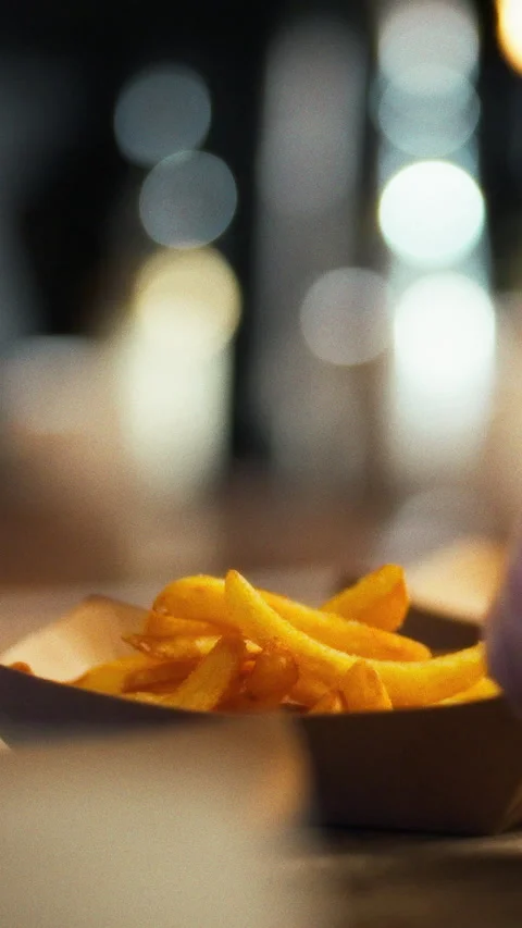 Hands skillfully serve steaming fries using wooden spoon in cozy kitchen fil Stock Footage 331598108