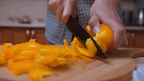 Hands Skillfully Slicing Yellow Peppers On Kitchen Wooden Table For Meal Stock Footage 329063831