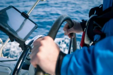 Hands of the skipper at the helm control of sailing boat Stock Photos