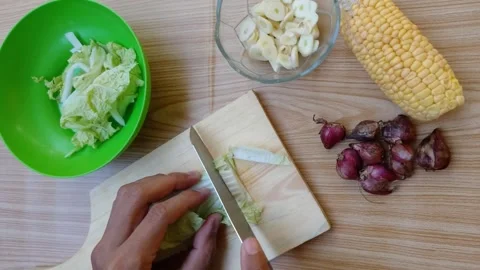 Hands slice cabbage on a wooden board Stock Footage 332470475