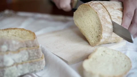 Hands slice loaves of bread. Stock Footage 89900332