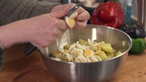 Hands slicing boiled eggs for a potato salad Stock Footage 331218554