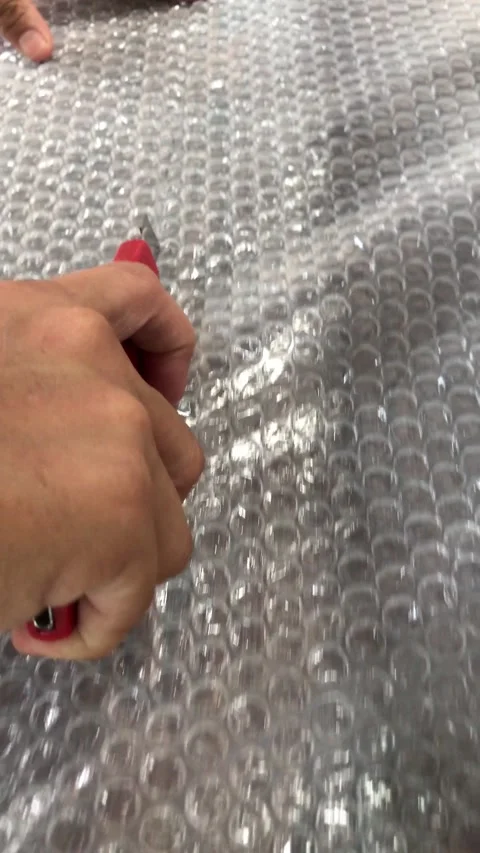 Hands Slicing Bubble Wrap Plastic with Utility Cutter Knife 4K Stock-Footage 337720617