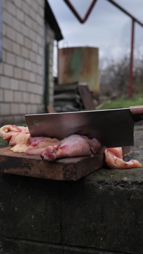 Hands slicing a chicken with a kitchen cleaver. Stock Footage 326028754
