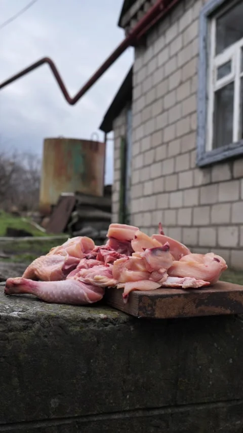 Hands slicing a chicken with a kitchen cleaver. Stock Footage 326028928
