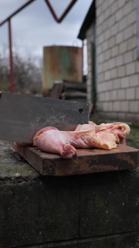 Hands slicing a chicken with a kitchen cleaver. Stock Footage 326029016