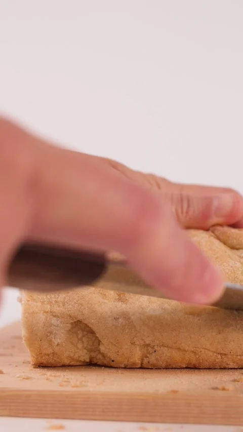 Hands Slicing Fresh Crusty Bread on Wooden Cutting Board Stock Footage 337767786
