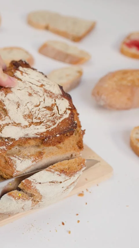 Hands Slicing Fresh Crusty Sourdough Bread on Wooden Board Stock Footage 338327341