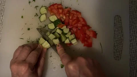 Hands slicing fresh cucumber and tomato on a cutting board Stock Footage 344421783
