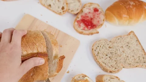 Hands Slicing Fresh Sourdough Bread on Wooden Board for Breakfast Stock Footage 337224962