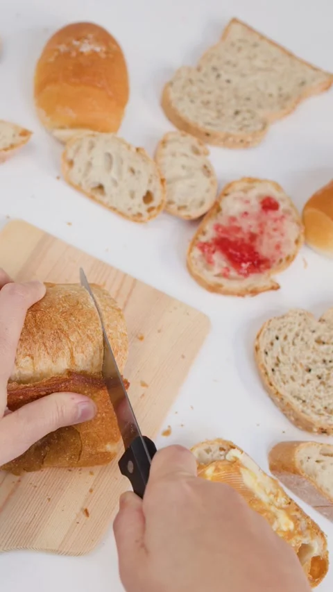 Hands Slicing Fresh Sourdough Bread on Wooden Board for Breakfast Stock Footage 337535086