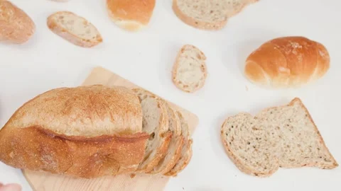 Hands Slicing Fresh Sourdough Bread on Wooden Board Stock Footage 337535363