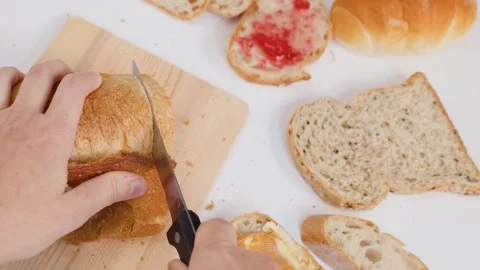 Hands Slicing Fresh Sourdough Bread on Wooden Board for Breakfast Stock Footage 337746731