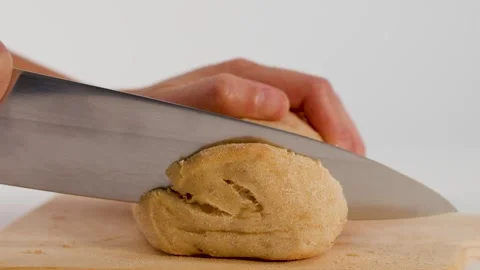 Hands Slicing Fresh Sourdough Bread on Wooden Cutting Board Stock Footage 339518905