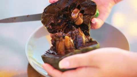 Hands slicing with knife one chocolate black sapote ripen fruit on white plate Stock Footage 164665804