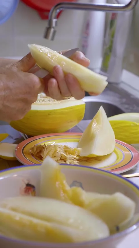 Hands slicing melon in the kitchen Stock Footage 303516469