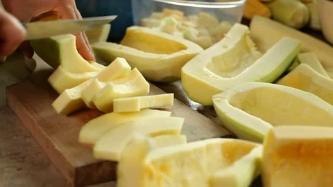 Hands slicing pumpkin pieces on cutting board 스톡 동영상 81079853