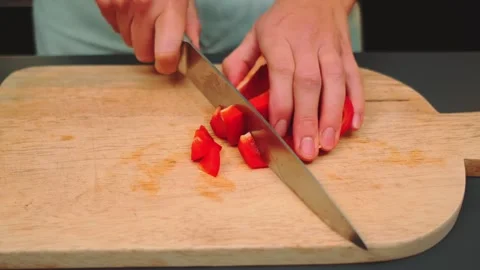 Hands slicing red bell peppers on wooden cutting board indoors 库存影片 342888222