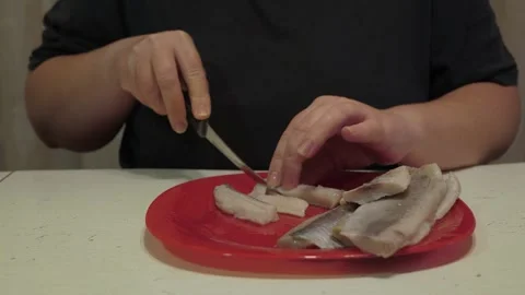 Hands slicing salted fish fillets into thin pieces Stockbeeldmateriaal 342362249